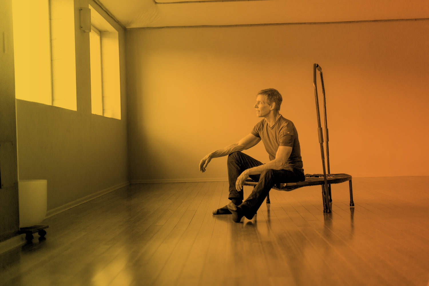 Dave Sitting on Cellercise Edge with Yellow and Orange Gradient Cellercise