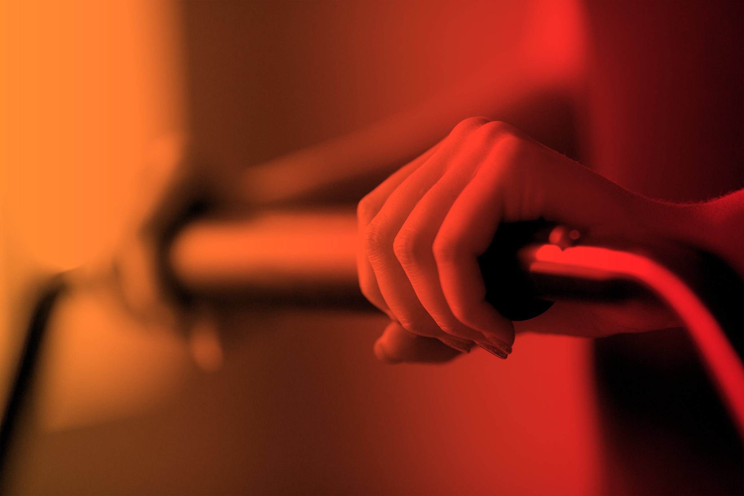 Hands on the Cellerciser Bar Orange and Red Gradient Cellercise