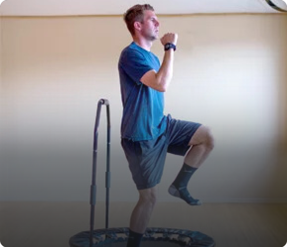 high knees exercise on mini trampoline rebounder with balance bar